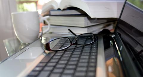 Image of laptop, glasses, and books