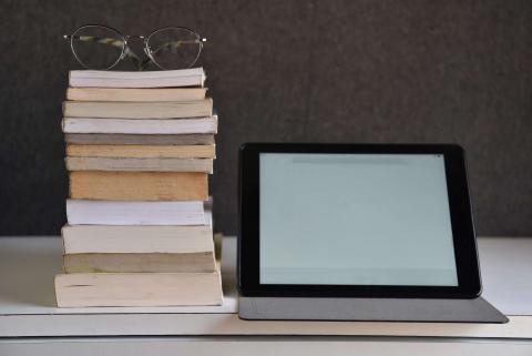 Image of glasses set on books next to laptop