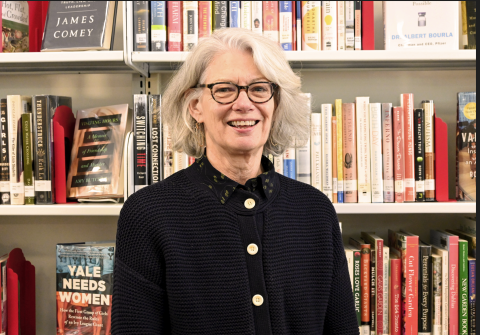 Susan smiling with bookshelves behind her
