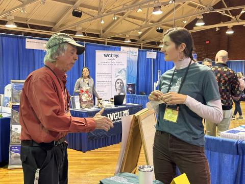 Lucy talks to participant at a conference